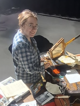 Meg Sharp smiling beside a production tabletop