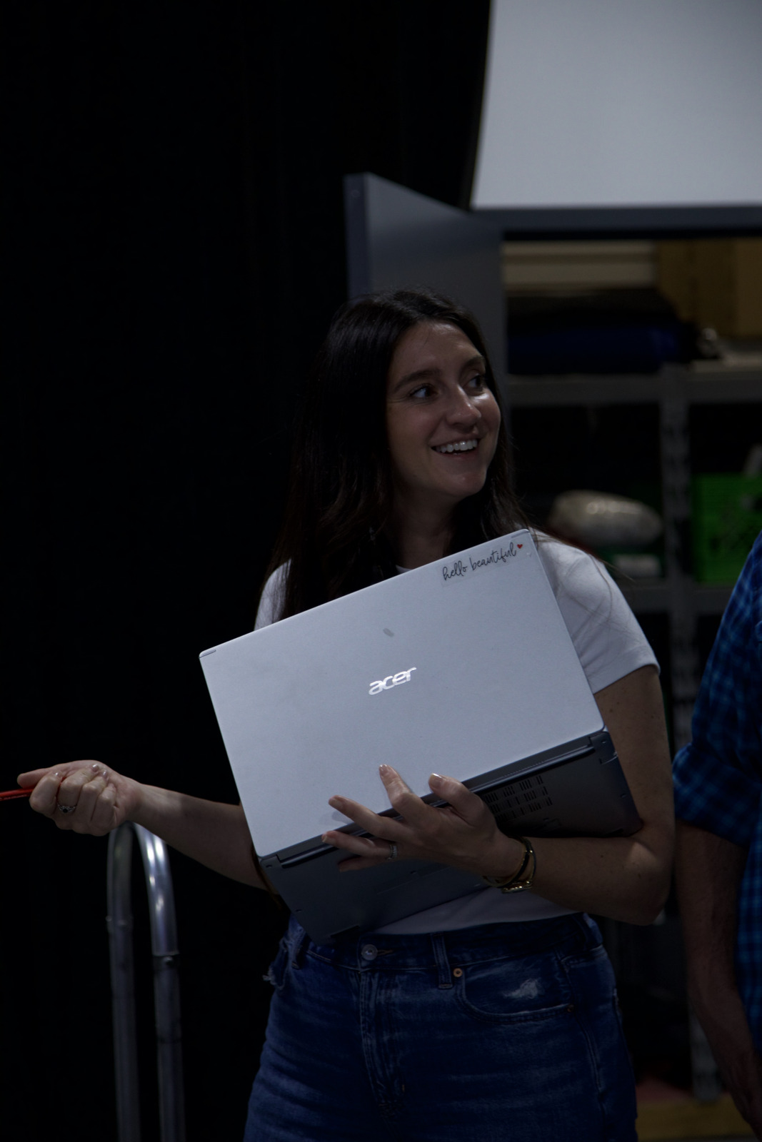 Keri Buchana with a laptop, talking with people on set